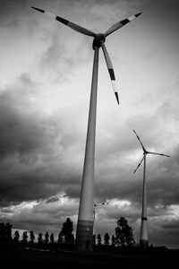 Low angle view of wind turbine against cloudy sky