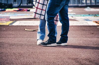 Low section of man standing on road