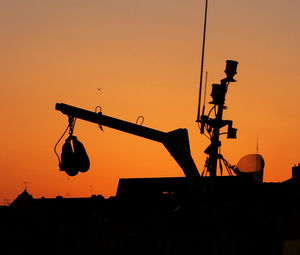Low angle view of silhouette crane against clear sky during sunset