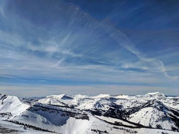 Scenic view of snowcapped mountains against blue sky