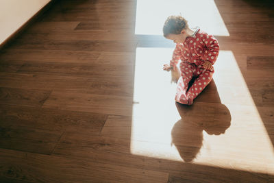 High angle view of cute girl sitting on floor at home