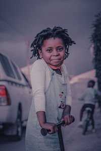 Portrait of smiling girl by car outdoors