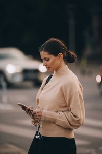 Young woman using mobile phone outdoors