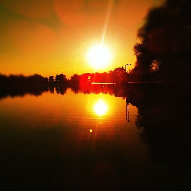 sunset, sun, orange color, silhouette, reflection, tranquil scene, scenics, water, tranquility, beauty in nature, lake, tree, sunlight, idyllic, nature, sky, lens flare, sunbeam, river, outdoors