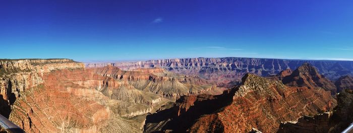 Panoramic view of rock formations against blue sky