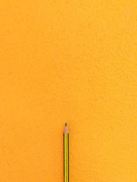 Close-up of pencils against yellow wall