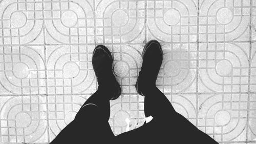 Low section of person standing on tiled floor