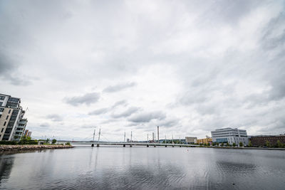 Bridge over river against buildings in city