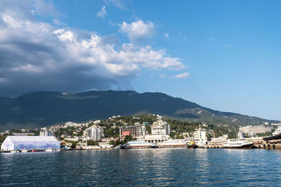 Scenic view of sea by buildings against sky