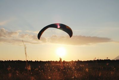 Silhouette person for paragliding on field