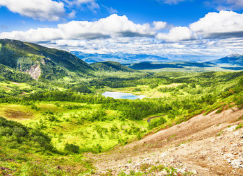 Summer view of valley with mounting, under blue sky with clouds