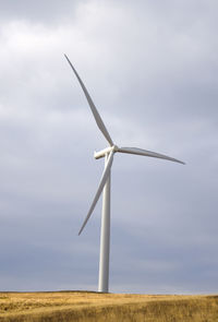 Windmill on field against sky