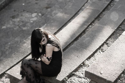 High angle view of young woman sitting on floor