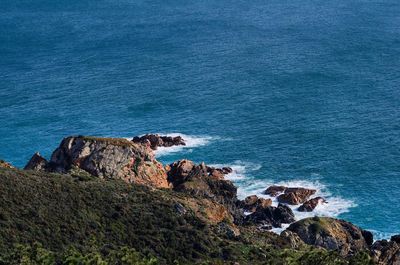 High angle view of rock formation by sea against sky