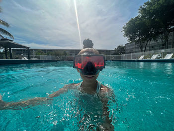 Girl swimming in pool in swimming mask 
