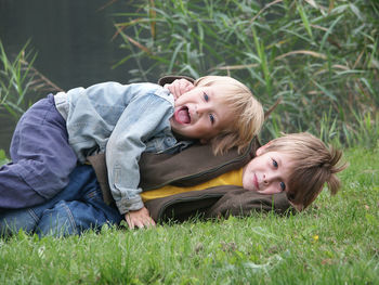 Portrait of cute siblings lying on grass