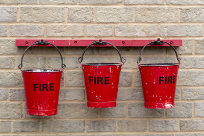 Close-up of red buckets hanging on a wall