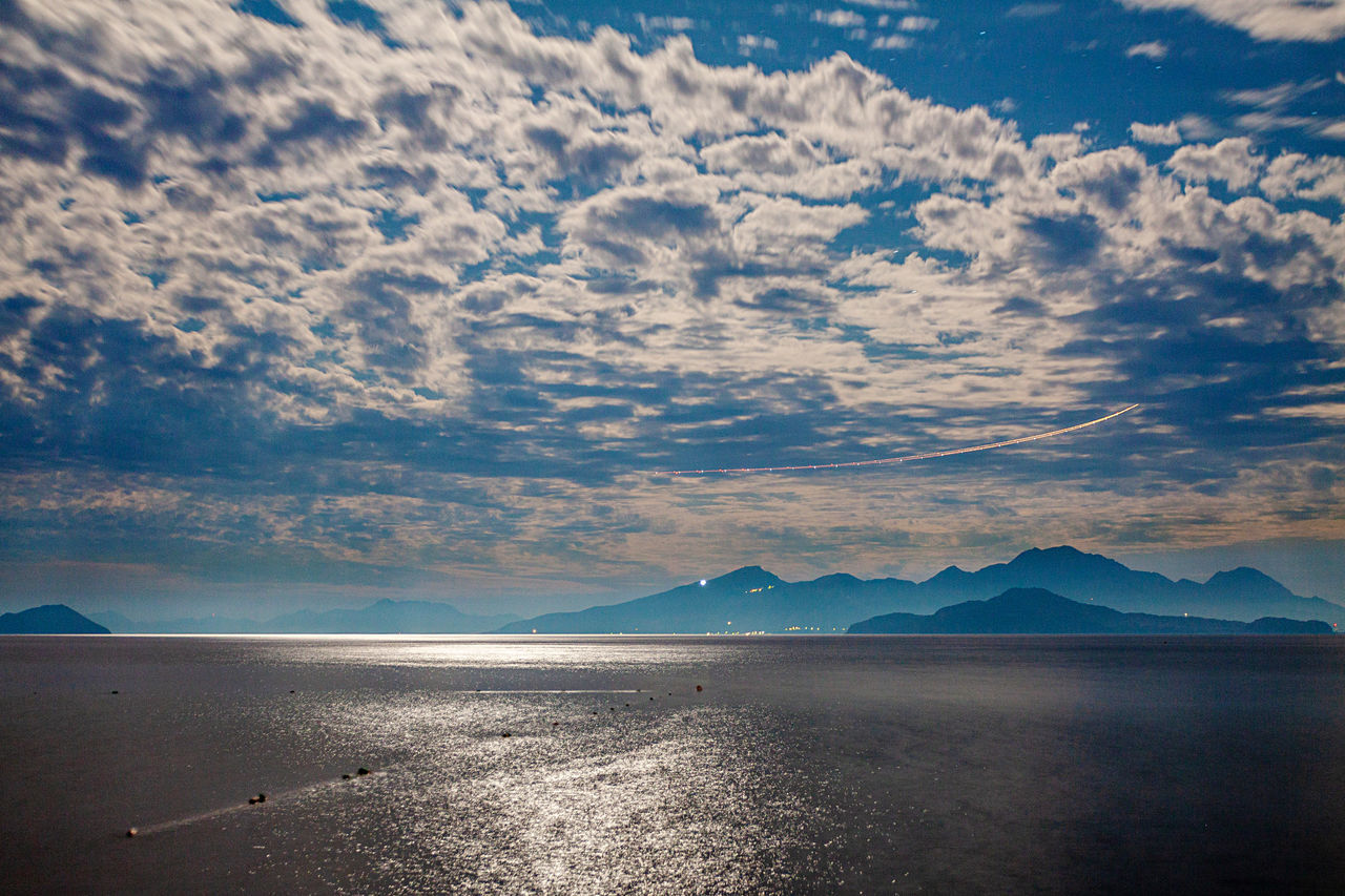 SCENIC VIEW OF SEA AGAINST MOUNTAINS