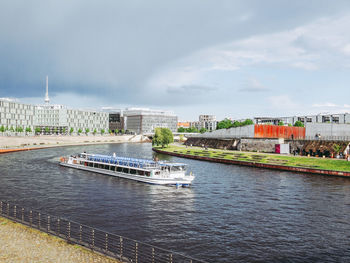 Scenic view of river by buildings against sky