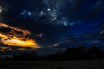 Scenic view of dramatic sky over land during sunset