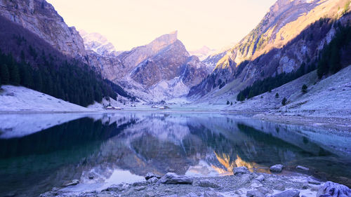 Scenic view of lake by mountains against sky