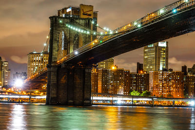 Illuminated bridge over river at night