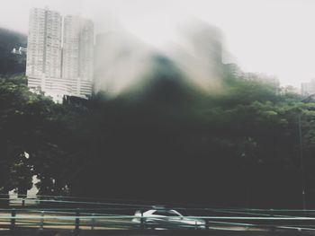 Blurred motion of buildings and trees in city