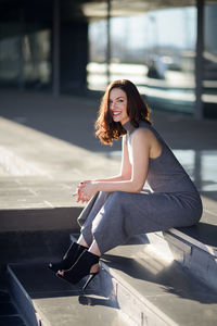 Portrait of smiling young woman sitting on steps