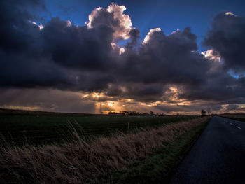 Scenic view of agricultural field against storm clouds