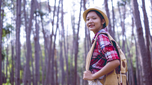 Young girl at pine forest wear hat and red shirt at phu pha man khonkaen thailand.