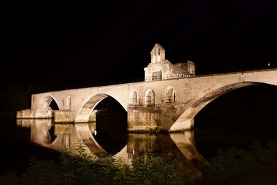Arch bridge against clear sky at night
