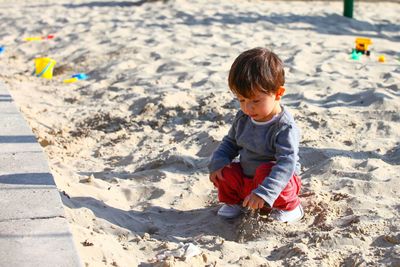 Close-up of boy playing with sand at beach