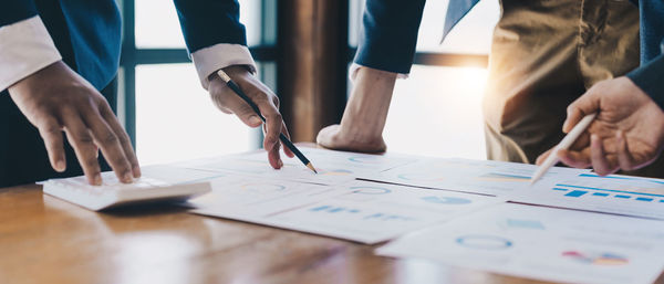 Midsection of business people working on table