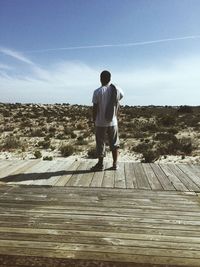 Rear view of man looking at landscape against sky. tróia beach in portugal