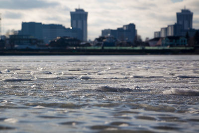 Close-up of river against cityscape