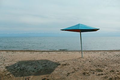 Lifeguard hut on beach against sky