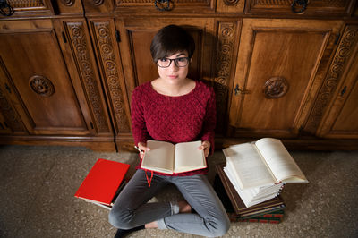 Young woman sitting on book