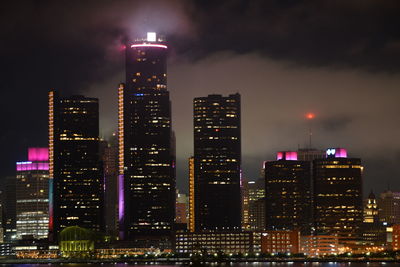 Illuminated buildings in city against sky at night