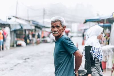 Side view portrait of senior man standing at market