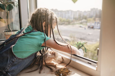 Midsection of woman sitting in car window