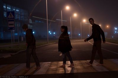 People standing in illuminated city at night