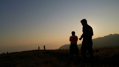 Man standing on field at sunset