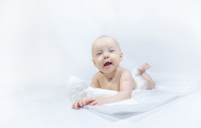 Portrait of cute baby boy lying on bed