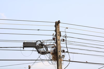 Low angle view of electricity pylon against clear sky