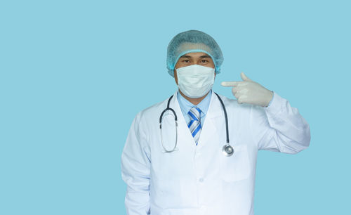 Portrait of man standing against blue background