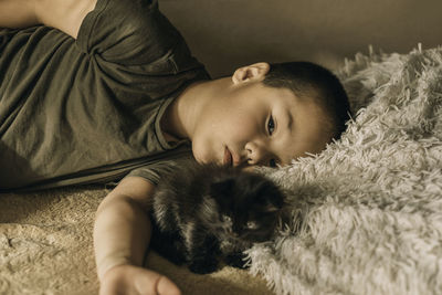 Portrait of an asian boy lying sad with a kitten