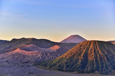 Scenic view of volcanic landscape against blue sky