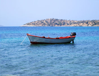 Boat moored in sea against clear sky