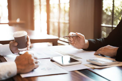 Man holding coffee cup on table