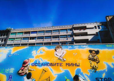 Graffiti on building against blue sky